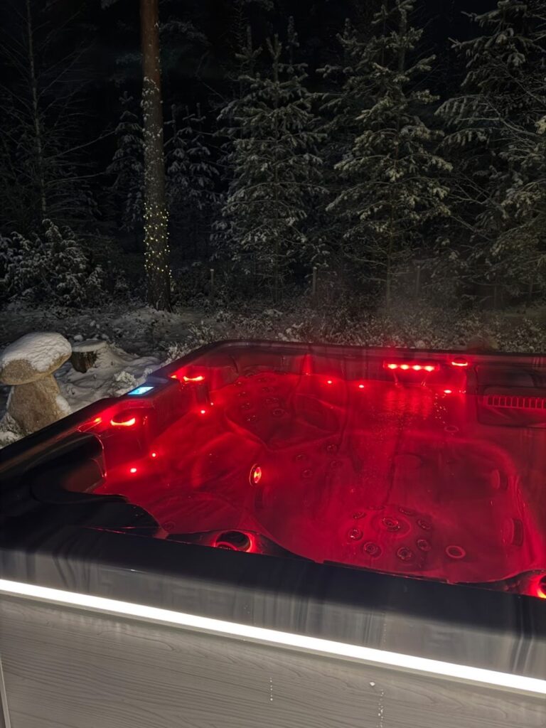 Punaisilla valoilla varustettu ulkoporeallas pimeällä.
