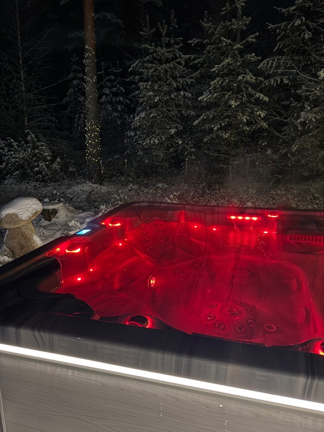 Punaisilla valoilla varustettu ulkoporeallas pimeällä.